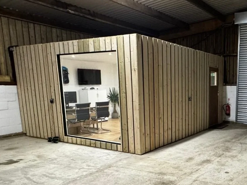 Finished timber-clad office pod with a large glass window, built inside a commercial unit in Sittingbourne